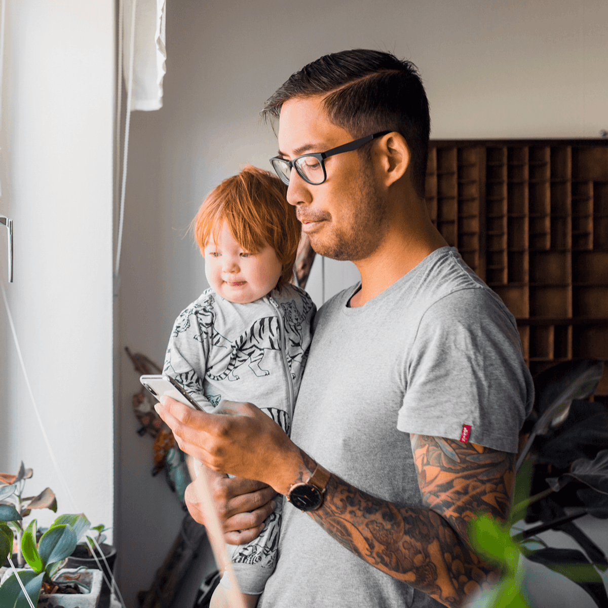 Dad and son by window looking at phone