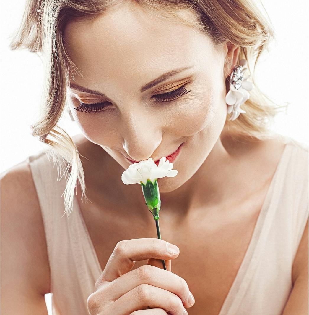 Woman smelling a flower showcasing ENT in Upper East Side.