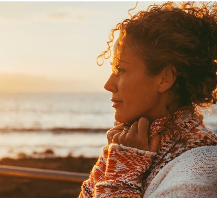 Side of a woman's face with the ocean in the background