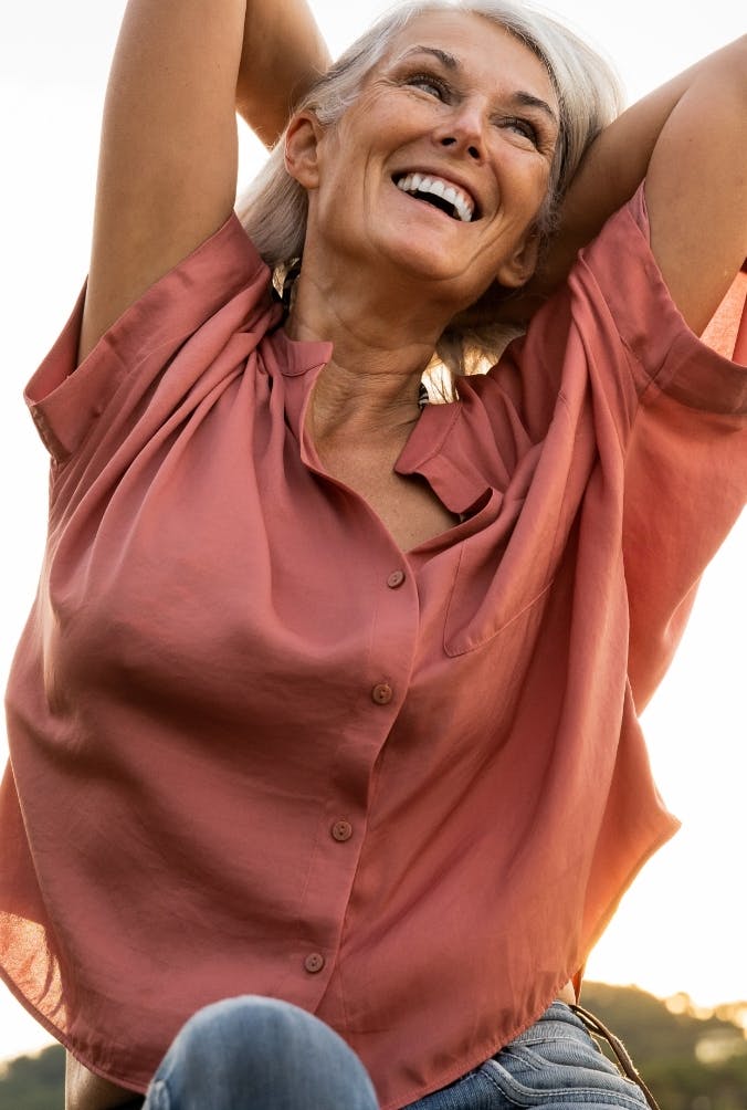 Older women in pink top looking happy.