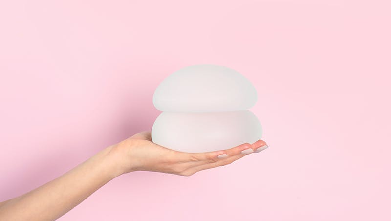 Hand holding breast implants