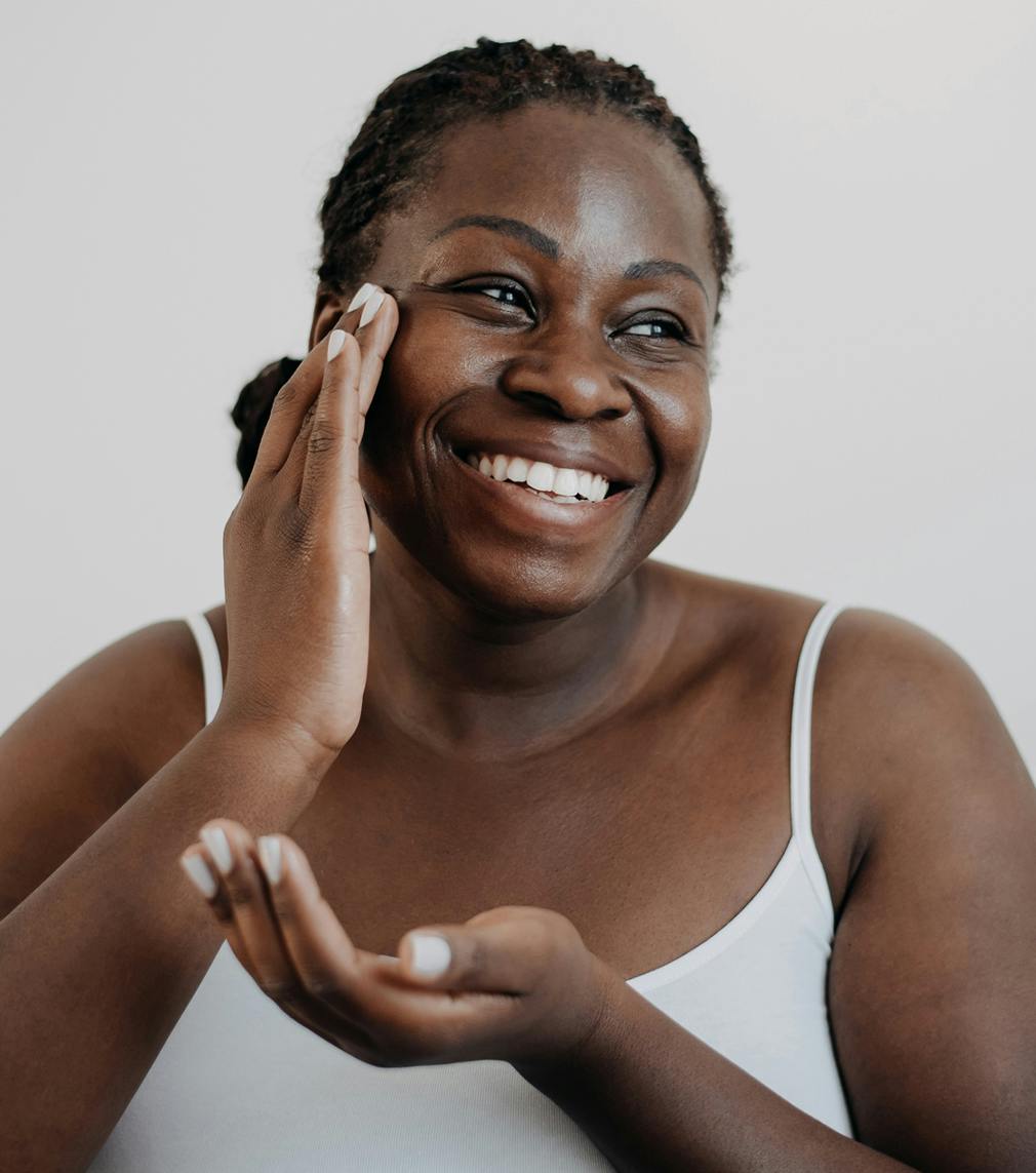 Woman putting lotion on her cheek