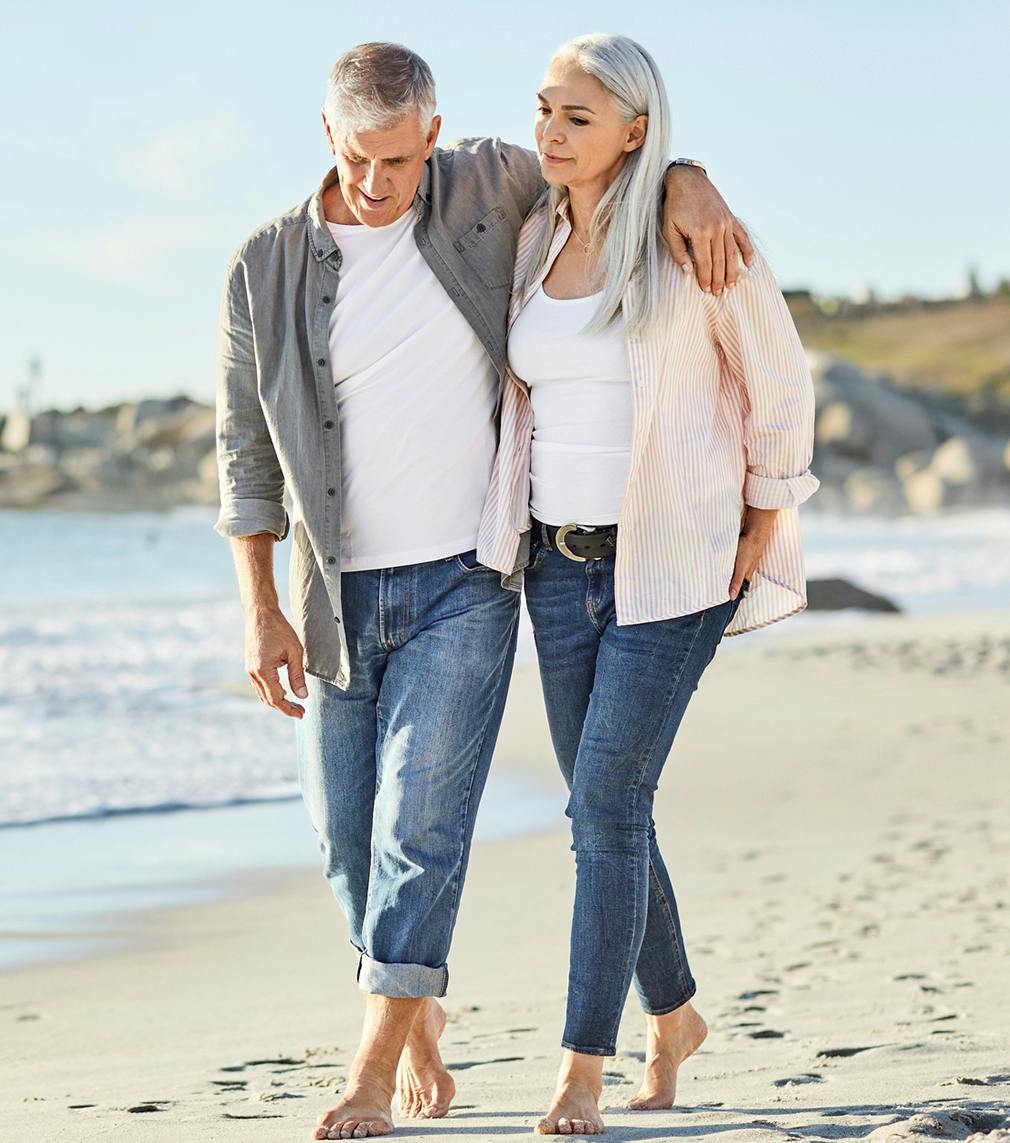 Elderly couple walking on the beach