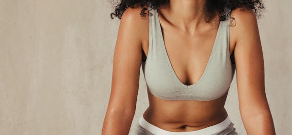 Woman in a gray bra with just her chest and stomach showing
