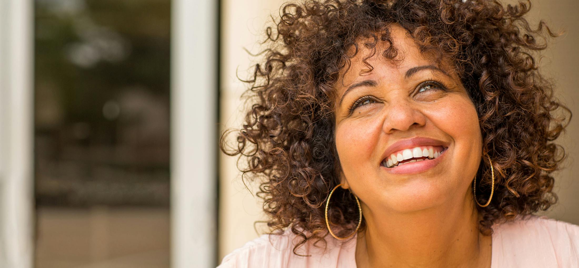 Woman with curly brown hair smiling