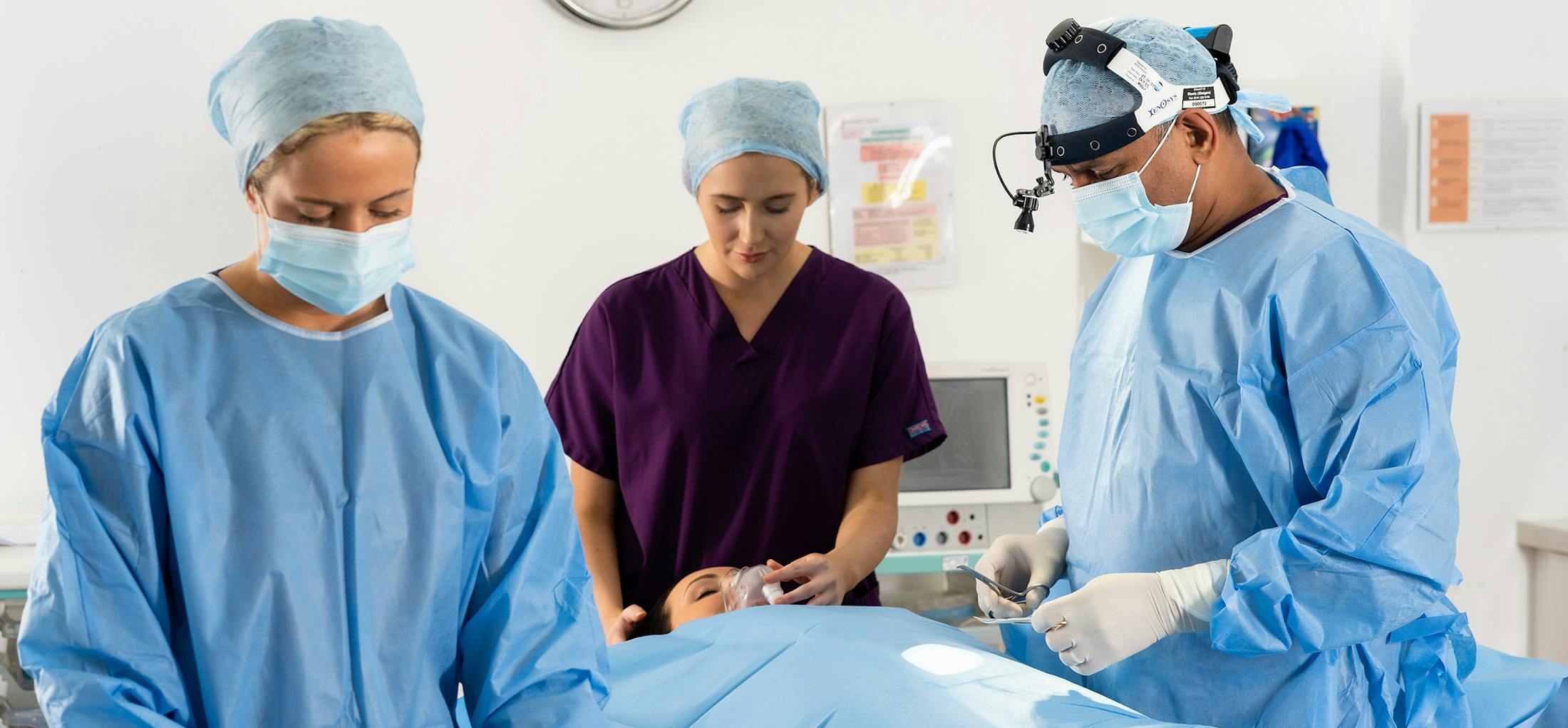 Woman on an operating table with three doctors around her
