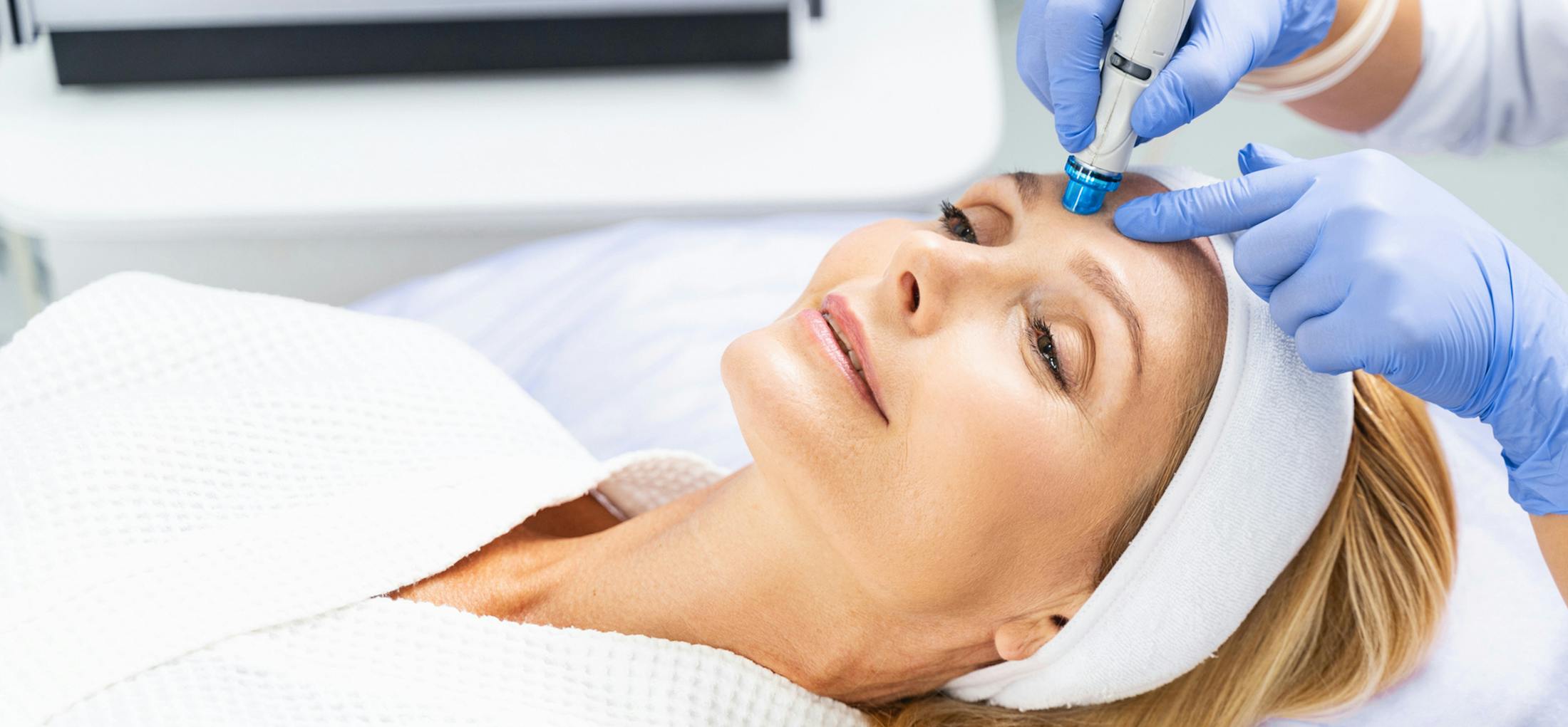 Woman getting treatment on her forehead from a doctor