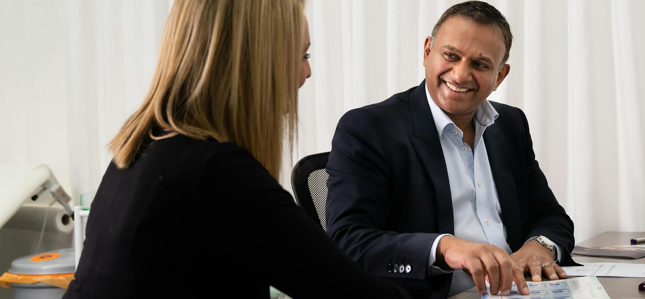 Man and woman sitting down looking at a piece of paper