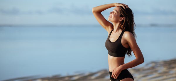 Woman in sports bra with her hand on her head