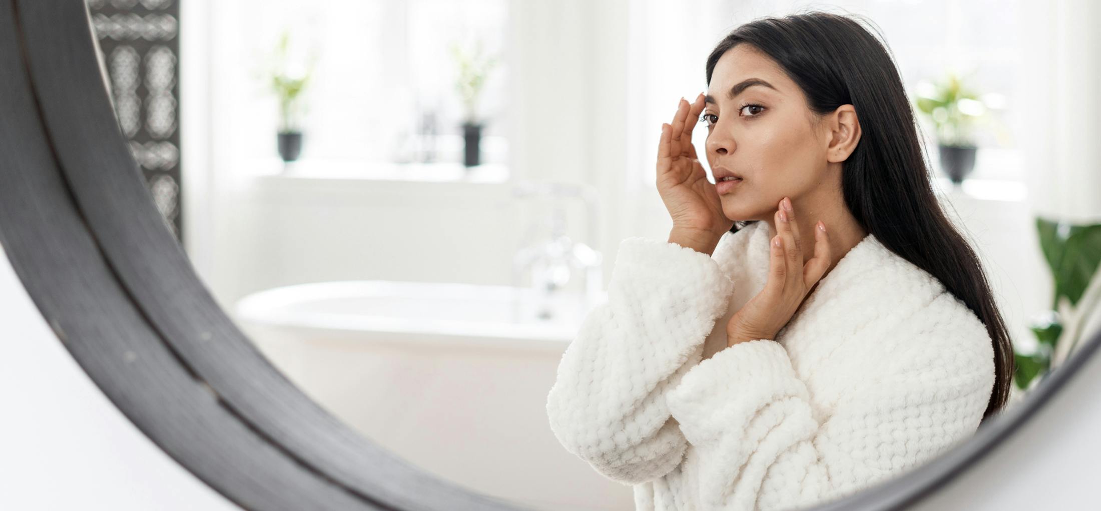 Woman looking at her face in the mirror