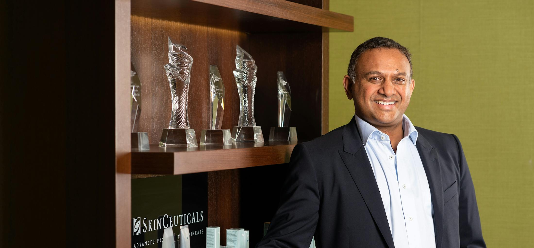 Doctor standing in front of awards on a shelf