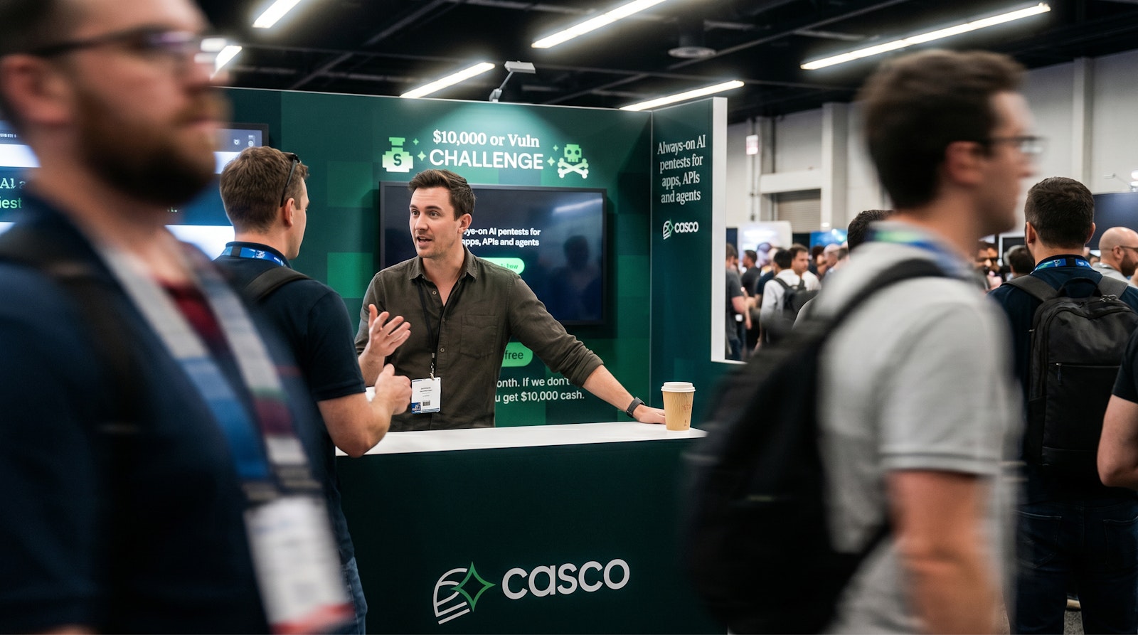 Photorealistic render of the Casco booth at a busy conference, with a rep talking to attendees in front of the $10,000 or Vuln Challenge wall