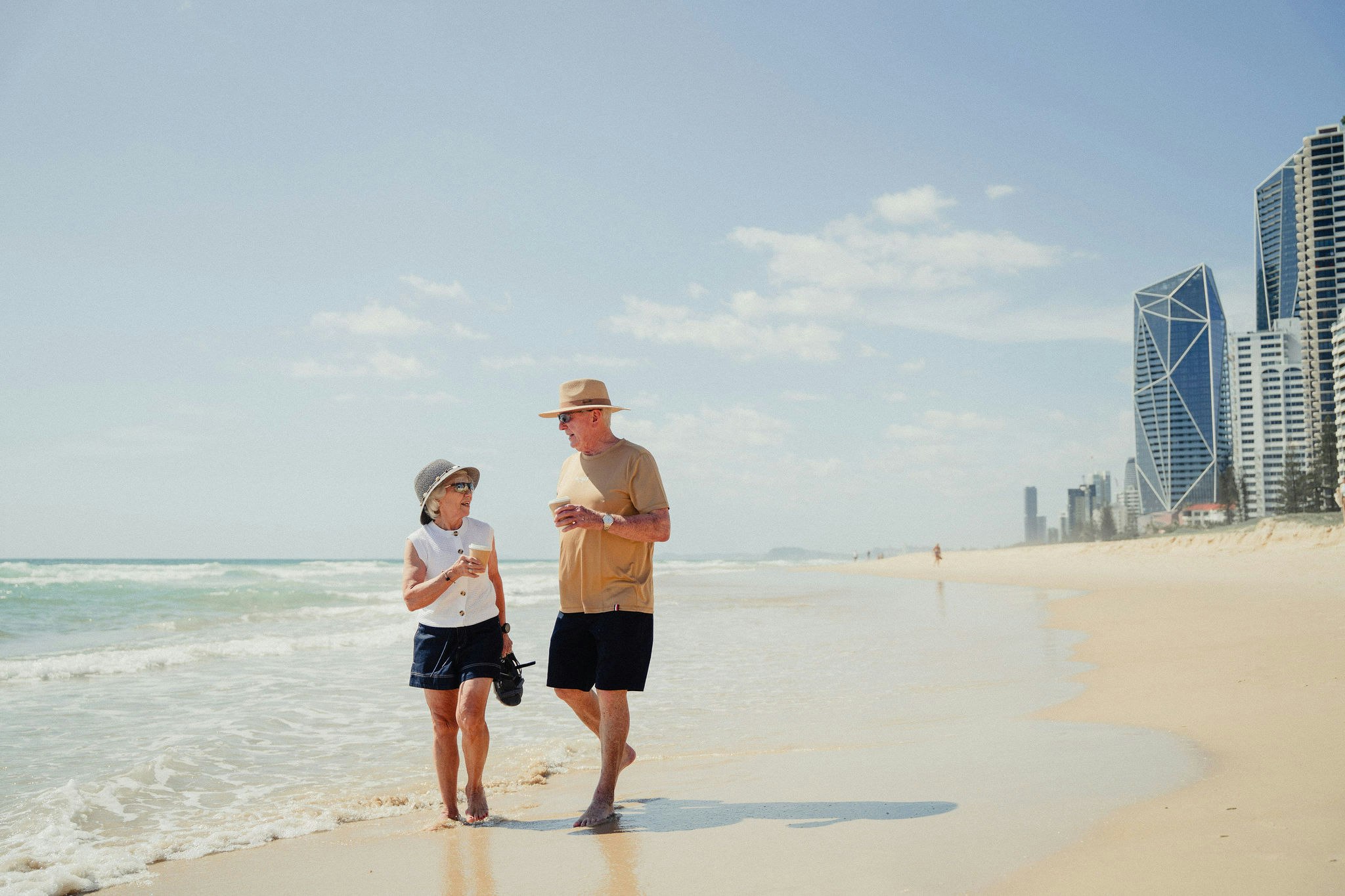 Older couple at Northcliffe Beach with city skyline backdrop