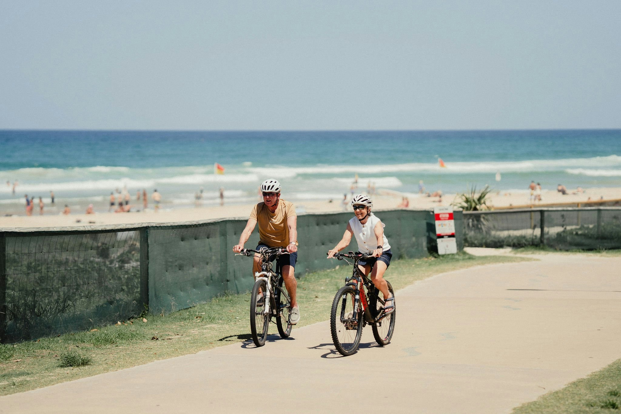 Couple cycling the Oceanway beside the beach on the Gold Coast