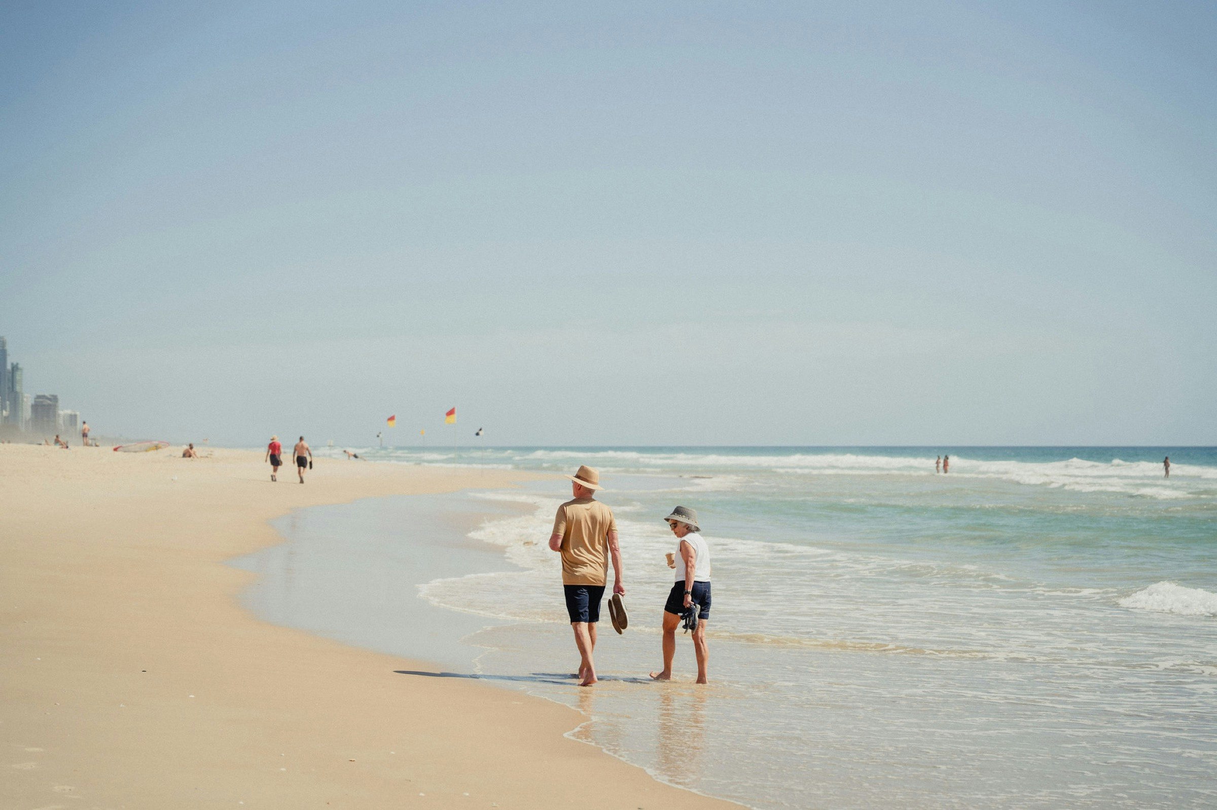 Couple walking along the water's edge on a Gold Coast beach