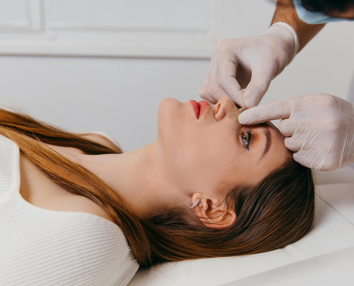 woman getting her nose checked by a doctor