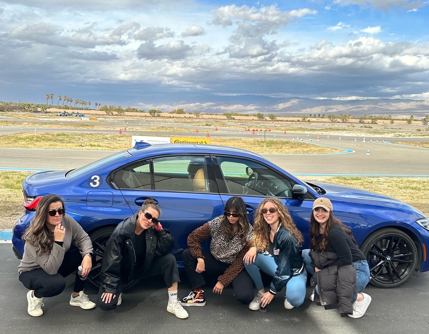 The women of Buildr right before breaking the sound barrier on the track behind them.
