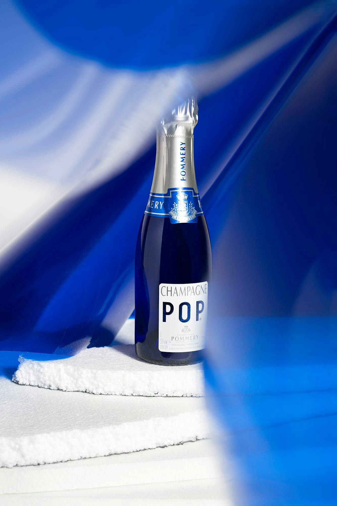 Une bouteille de Pommery Pop 20cl sur fond bleu et blanc