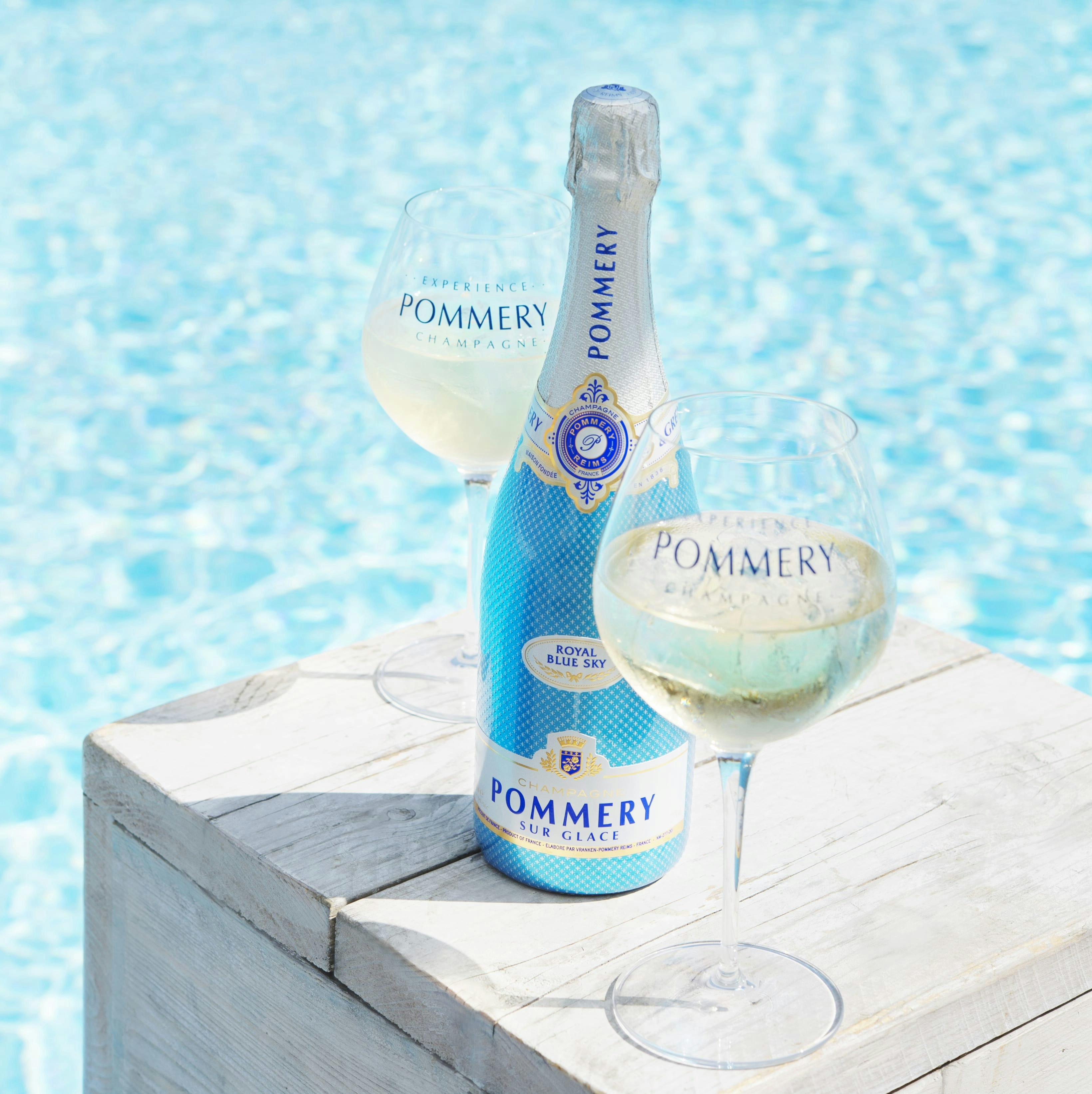 A bottle of Pommery Royal Blue Sky 75cl near the pool with 2 glasses