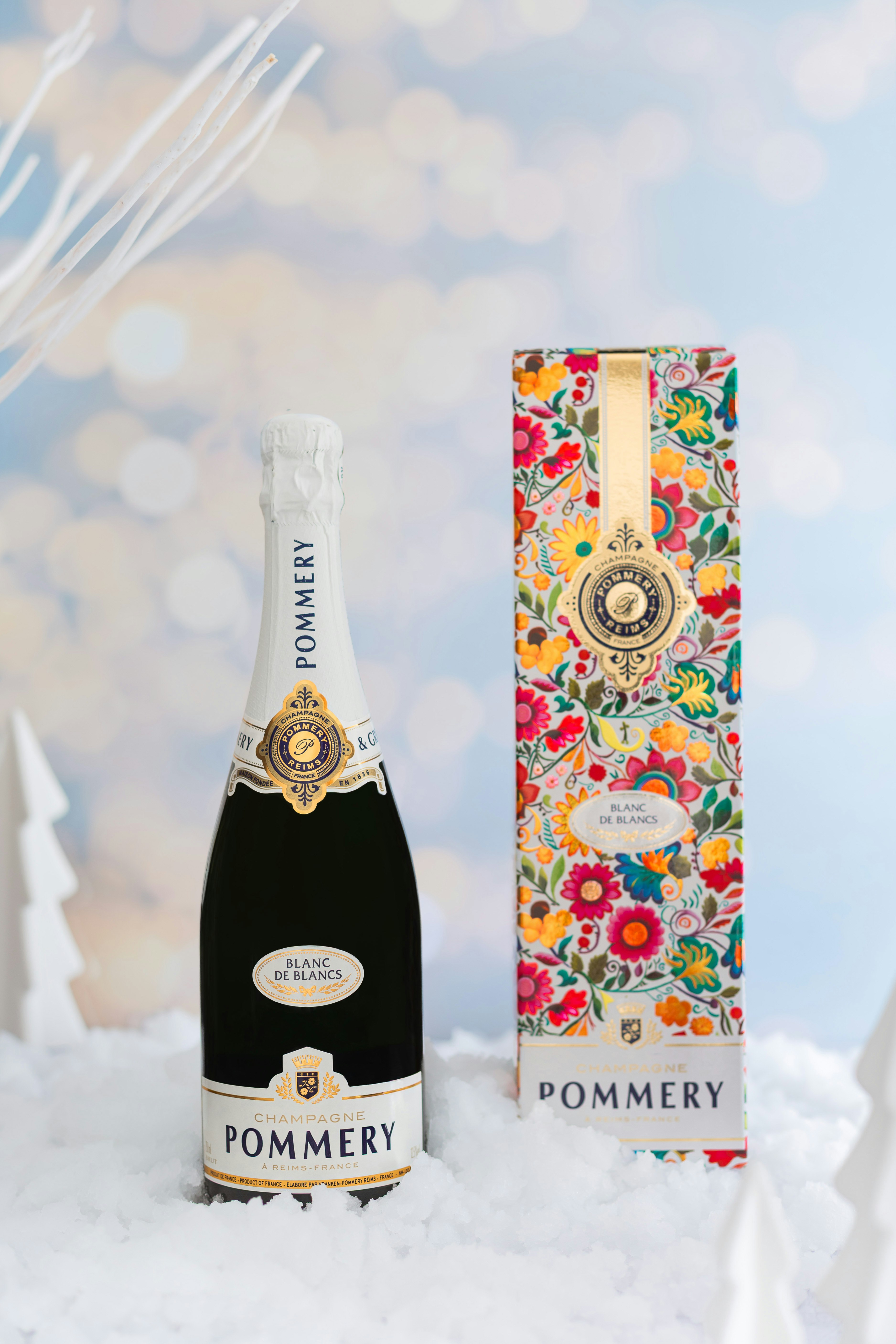 Bottle of Pommery Apanage Blanc de Blancs with glass and plate on table