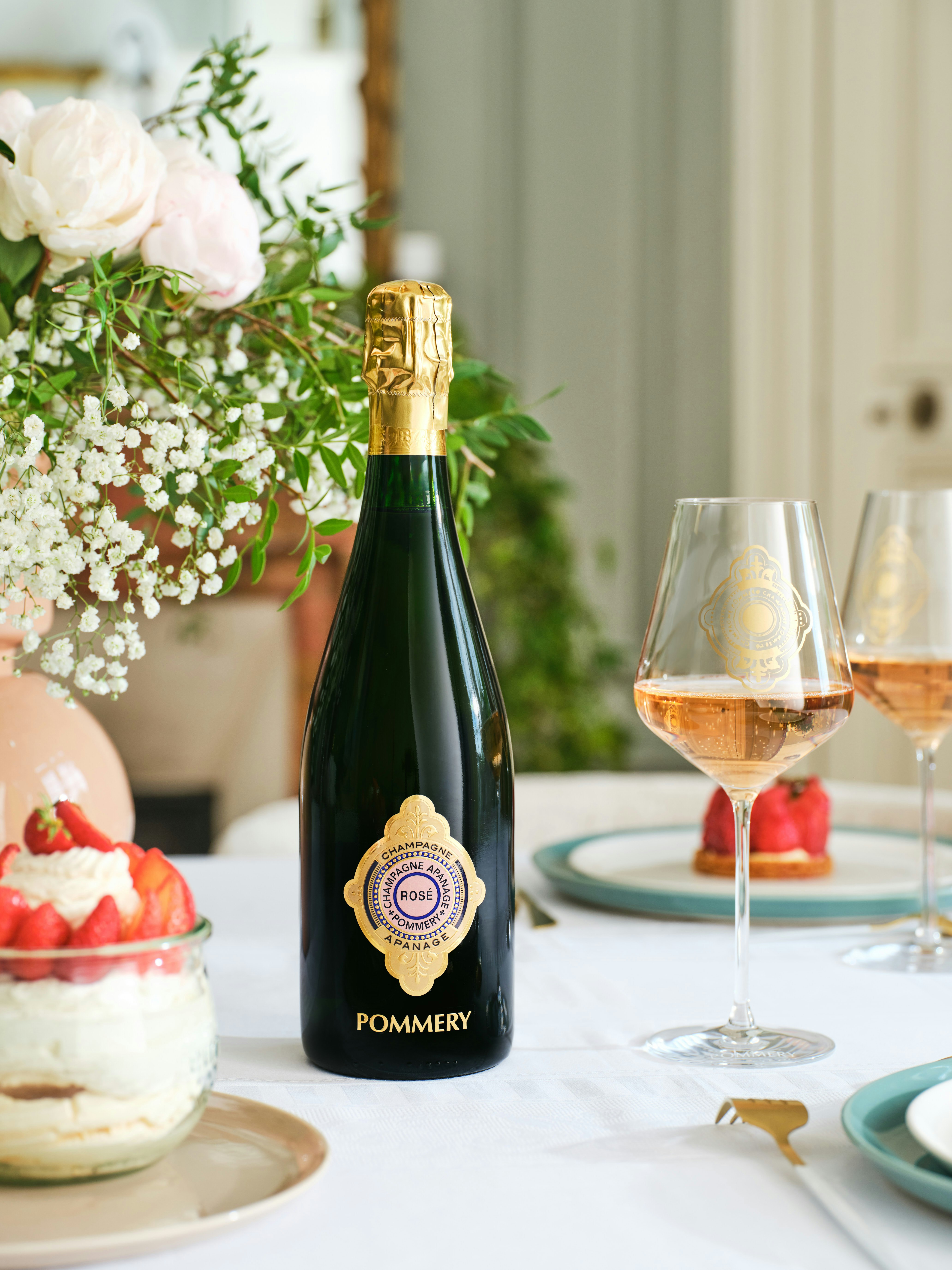 Une bouteille d'apanage rosé 1874 75cl sur une table à coté d'un dessert et d'une coupe