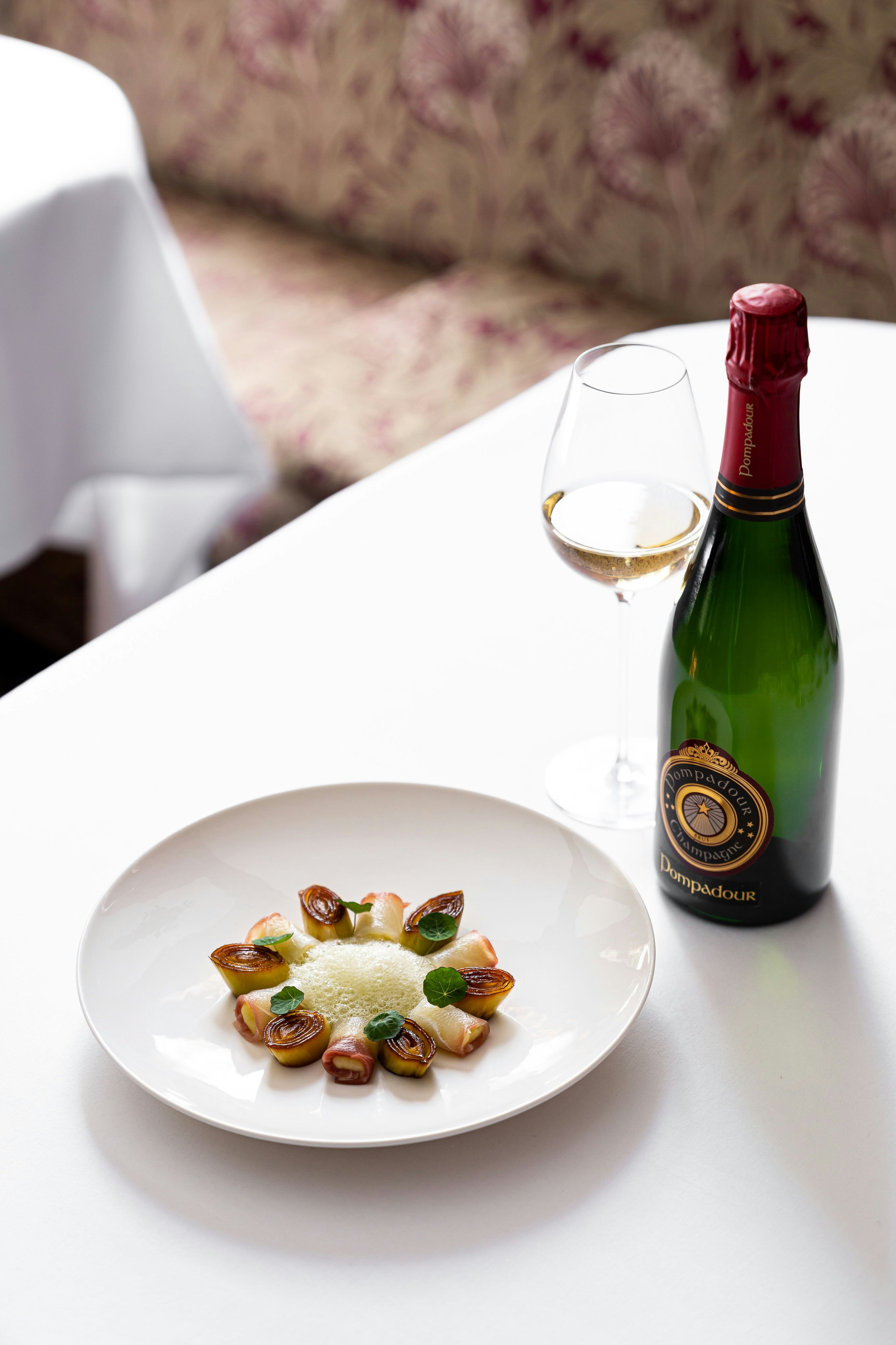 Une bouteille de Pompadour La Réserve 75cl sur une table avec une assiette
