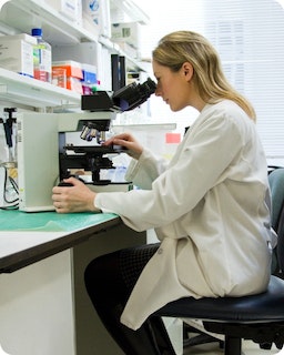 Scientist microscope A scientist looks through a microscope