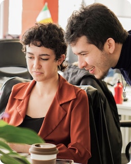 An employee looks over the shoulder of his colleague