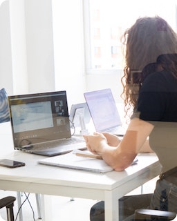 Frau arbeitet in einem Homeoffice und spricht mit ihren Kollegen in einem Videoanruf