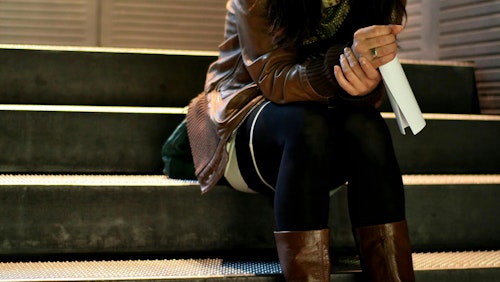 Brünette Frau sitzt auf der Metalltreppe