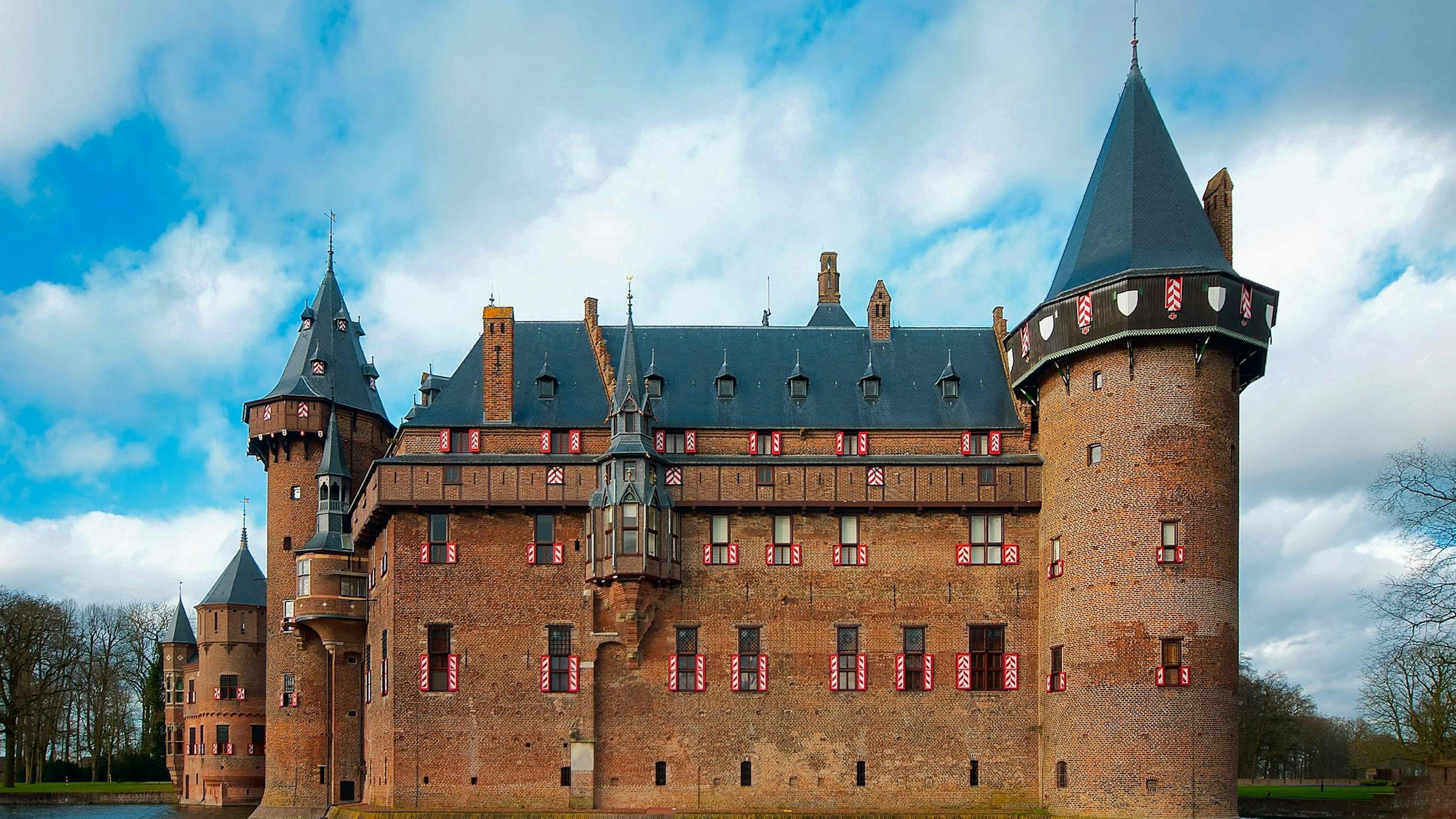 Majestätisches gotisches Schloss De Haar mit einem Wassergraben unter strahlendem Himmel, Utrecht, Niederlande.