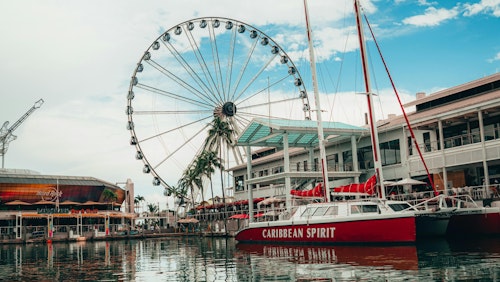 Malerische Aussicht auf den Jachthafen von Miami mit Riesenrad, Yacht und lebendiger städtischer Umgebung.