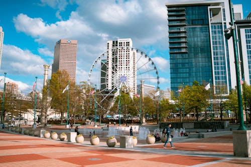 Tagesansicht des Centennial Olympic Park mit Wolkenkratzern und Riesenrad in Atlanta, Georgia.
