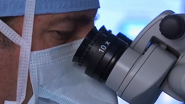 close up of doctor looking into ORA system microscope 