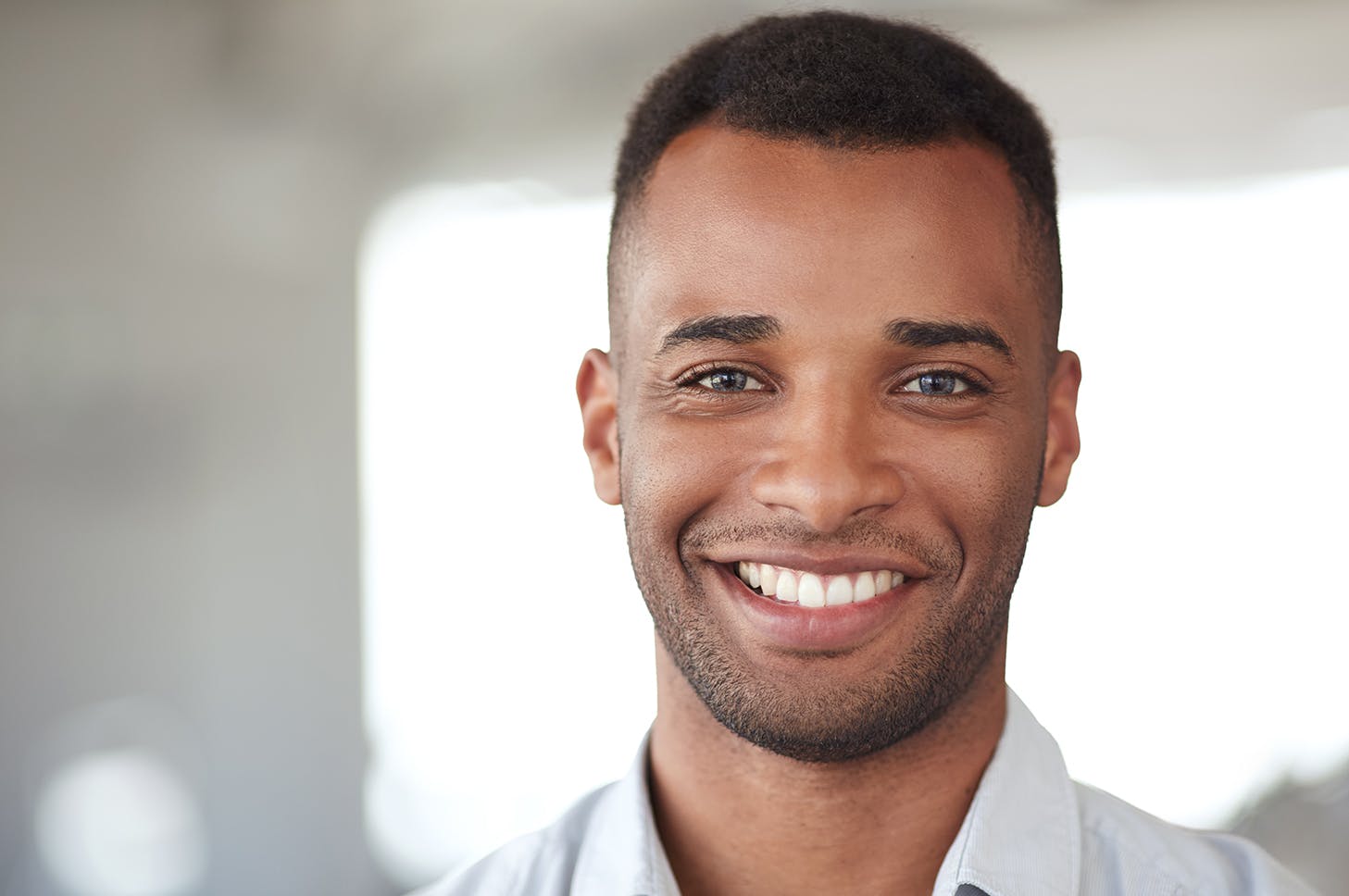 smiling man in white shirt and tie looking at camera