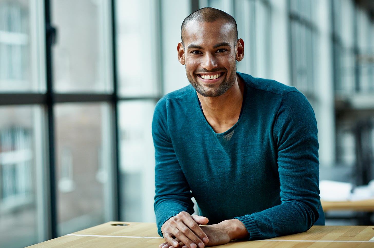 smiling man sitting at a table with a pen in his hand