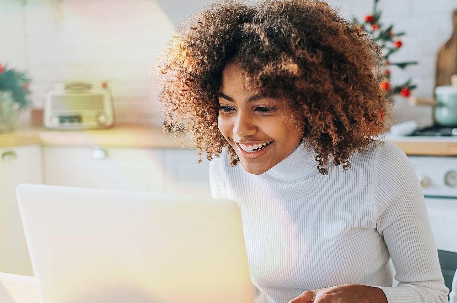 Black lady smiling and looking at her laptop
