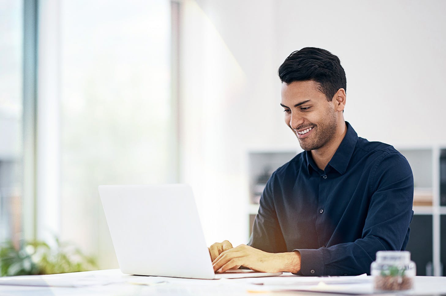 man working at his laptop smiling