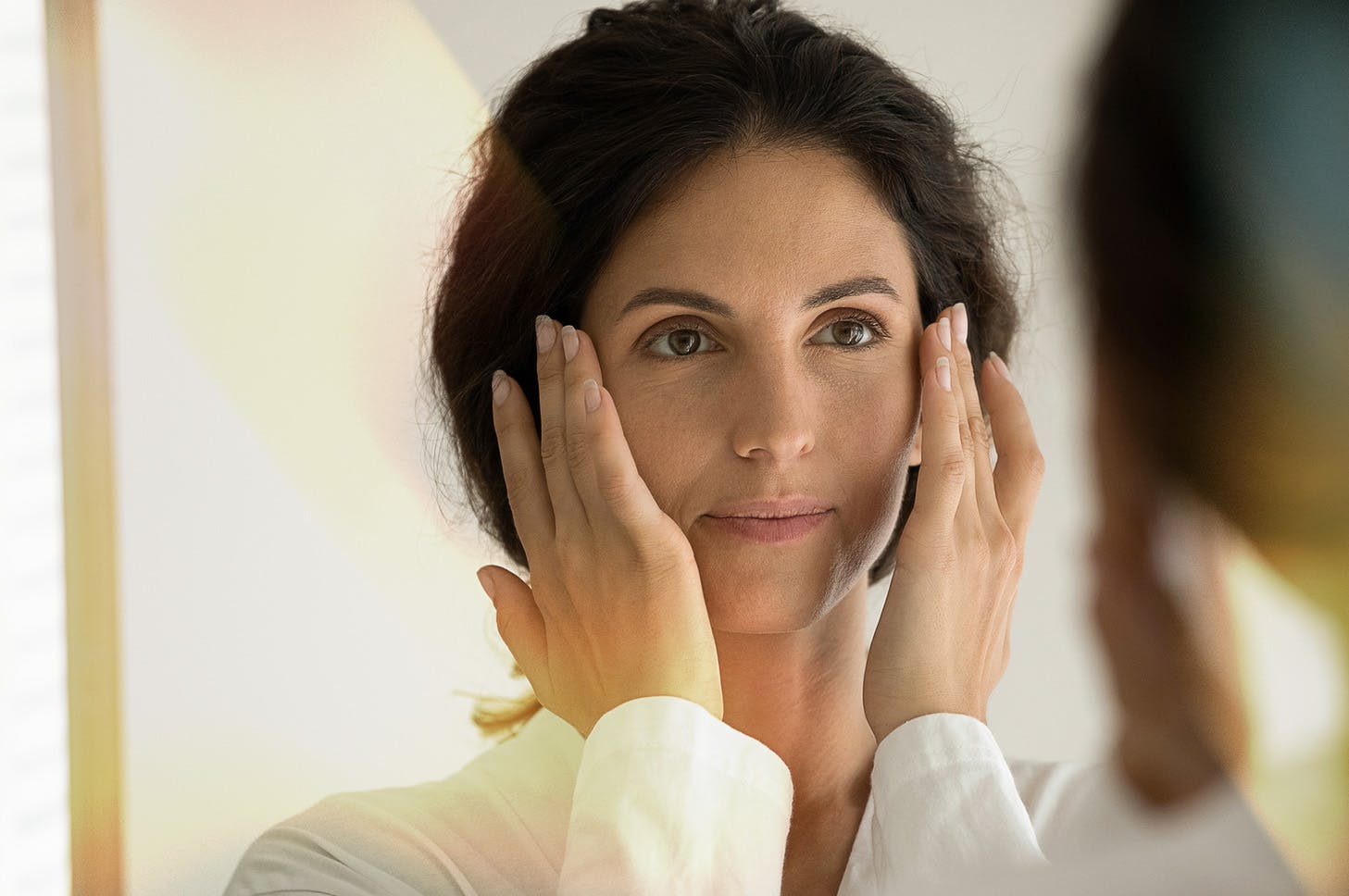 lady looking into the mirror and examining her eyes