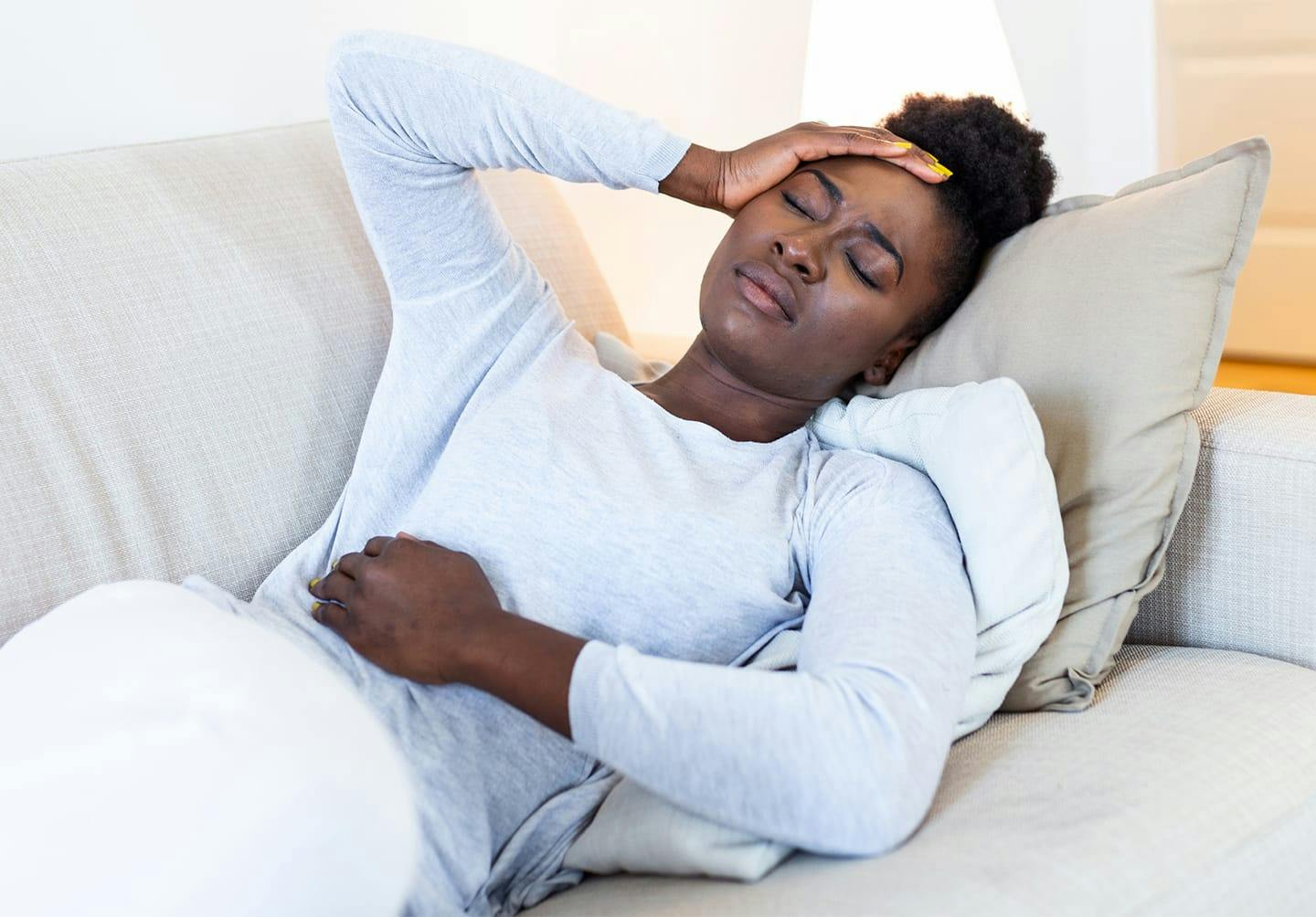 Woman lying down holding her head