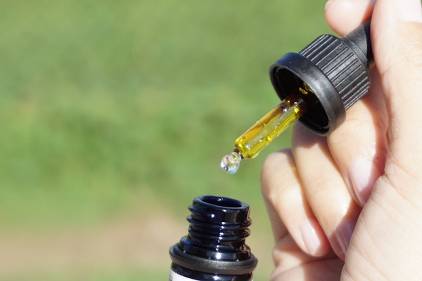 A person holding a bottle of CBD oil 