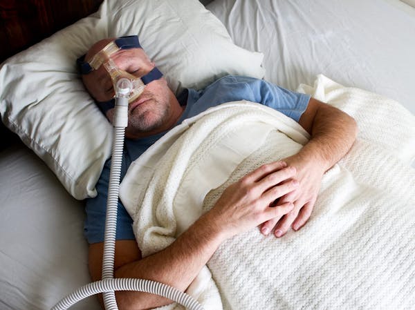 man sleeping with cpap machine