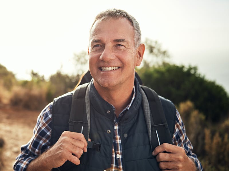 Middle-aged man wearing a backpack on a hike