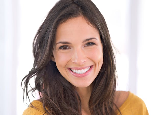 Brunette-haired woman wearing a yellow shirt