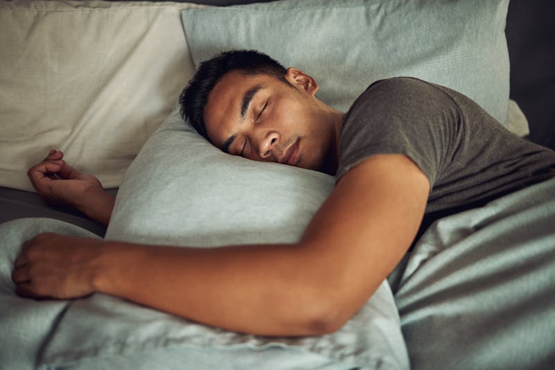Young man sleeping in a bed