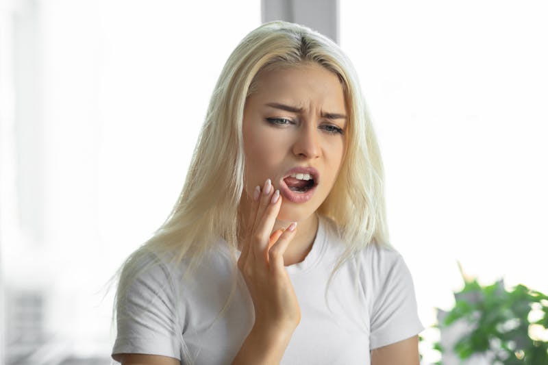 Woman touching her jaw in discomfort