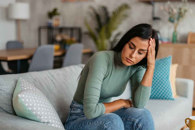 Woman touching her head in discomfort