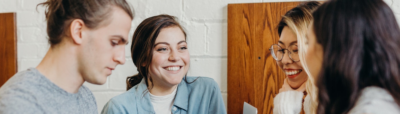 Op de afbeelding zijn vier studenten aan het overleggen