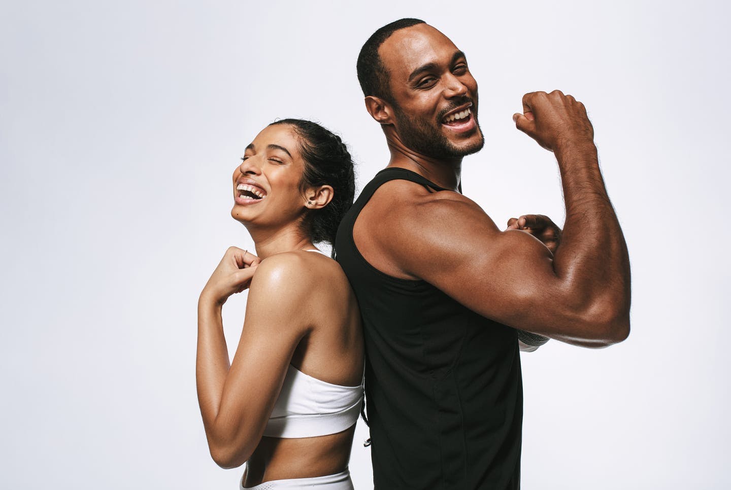 A man and woman flelxing arms and laughing