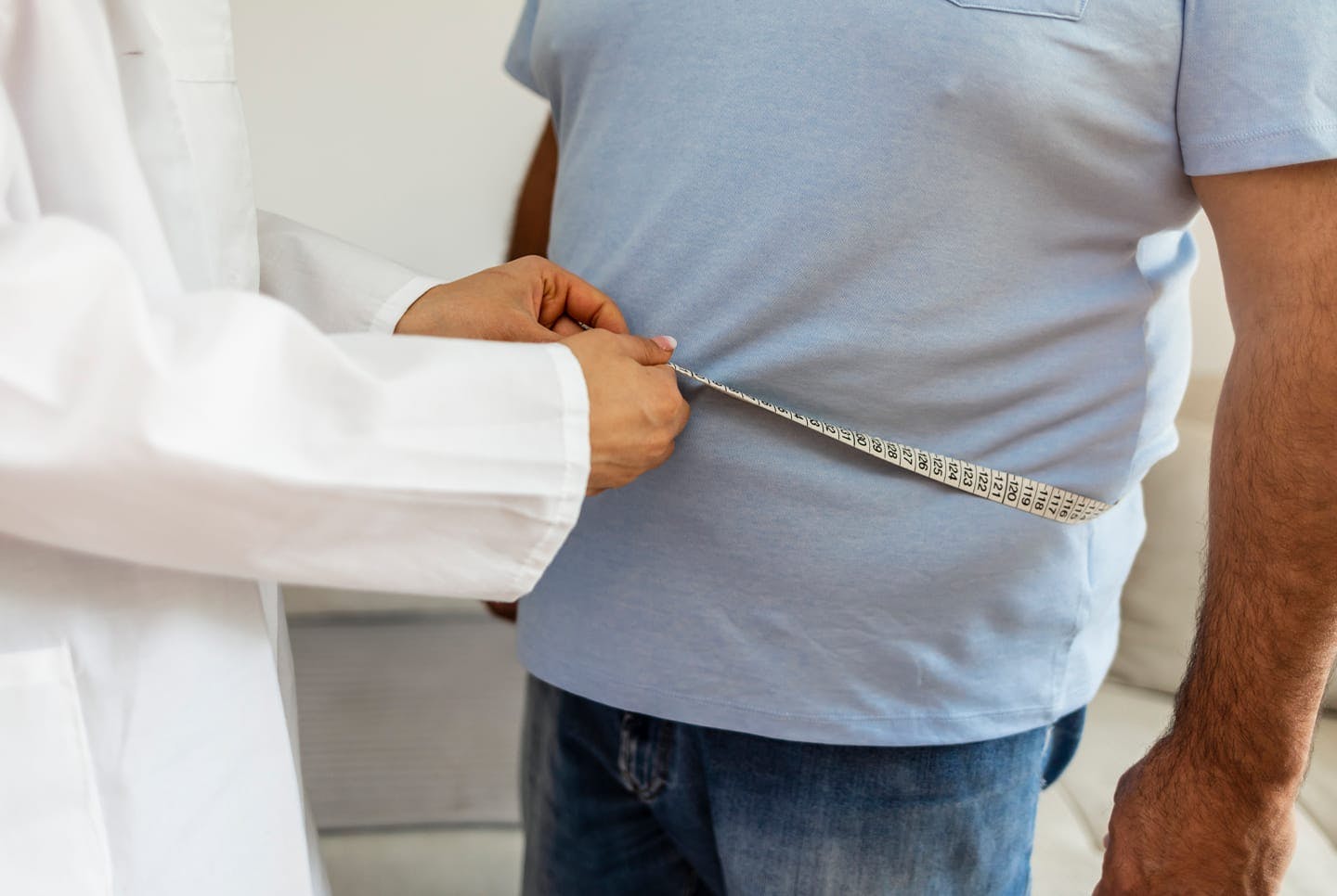 man getting waist measured